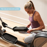 Nordic Track SE7i Elliptical Trainer. Female demonstrating how to alter the angle of the footplates.