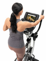 Nordic Track SE7i Elliptical Trainer. female working out on the cross trainer looking at the console.