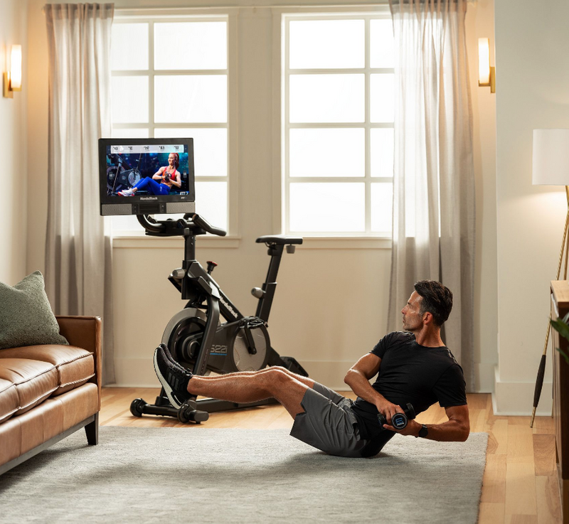 Nordic Track S22i Studio Bike in room with male model exercising on the floor