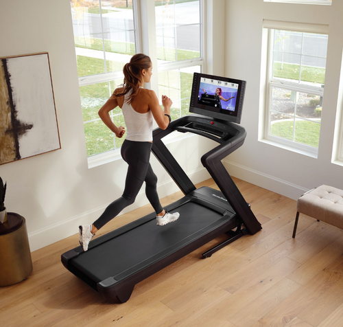 Nordic Track Commercial 2450 Treadmill with female running in room setting 
