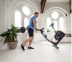 Flow Fitness DHT 2500i Upright Bike being moved by male model in room