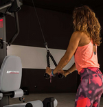 BH G128 Indar Light Commercial Multi Gym with Leg Press with female model using tricep rope from lat pulldown station