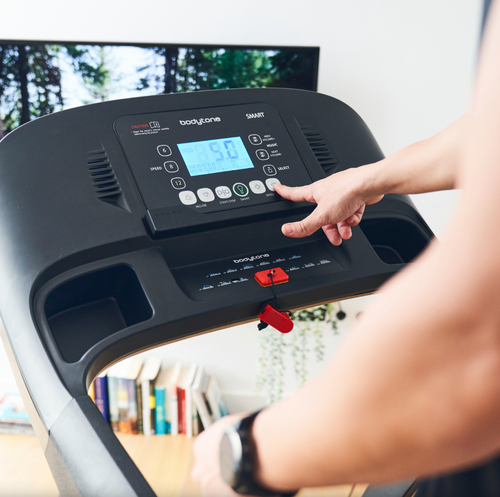 Person using a Bodytone Active Run LED treadmill with consoles digital display in a home setting
