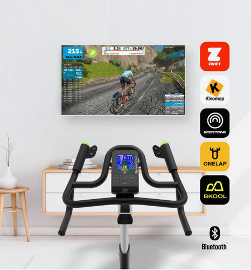 Bodytone Smart Bike V3 with screen displaying cycling route on TV and various app icons on a white wall.