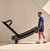 Bodytone ZROT4 Light Commercial Curved Treadmill being moved by man pushing it along on its transport wheels