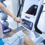 Dyaco Medical Physical Therapy Recumbent Bike 4.0R in gym room showing a close up of the console with therapist pressing one of the consoles buttons.