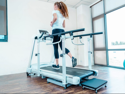 Dyaco Medical Rehabilitation Treadmill 7.0T rear view with female patient walking on it in gym room.