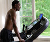 Horizon 7.4AT treadmill with black male model viewing tablet in room setting