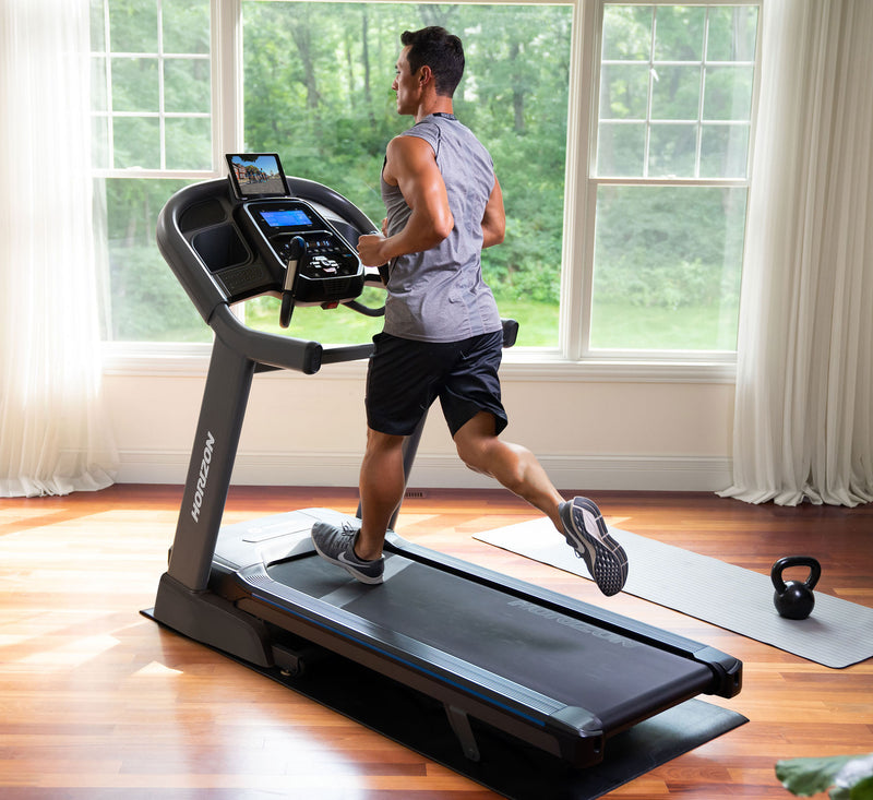 Horizon 7.4AT treadmill with male running in room setting