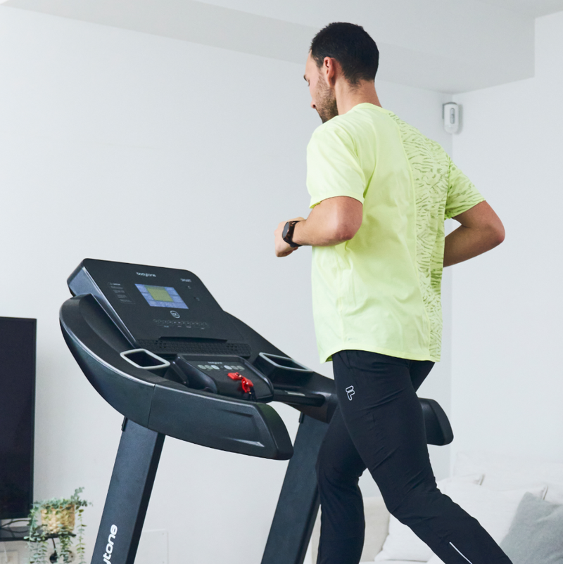 Man exercising on a Bodytone Active Run 600 Smart treadmill in a home setting