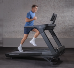 Man running on Inspire Fitness T7S treadmill against a brick wall.