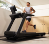 Man running on Inspire Fitness T7S treadmill in a modern indoor setting