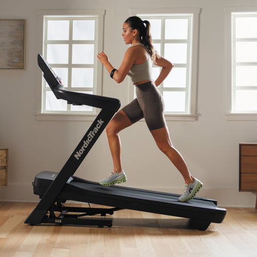 Nordic Track EXP 10i Treadmill with female running on incline in room