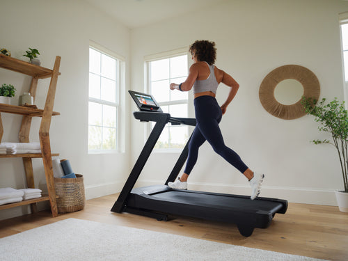 Nordic Track EXP14i Treadmill with woman running on it in living room