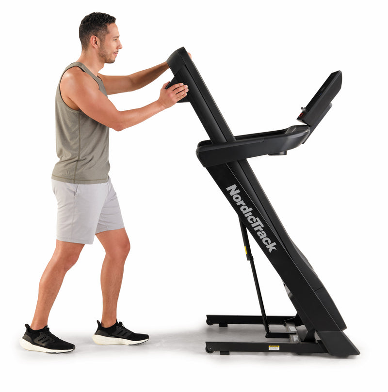 Nordic Track EXP 5i Treadmill folded by male in studio