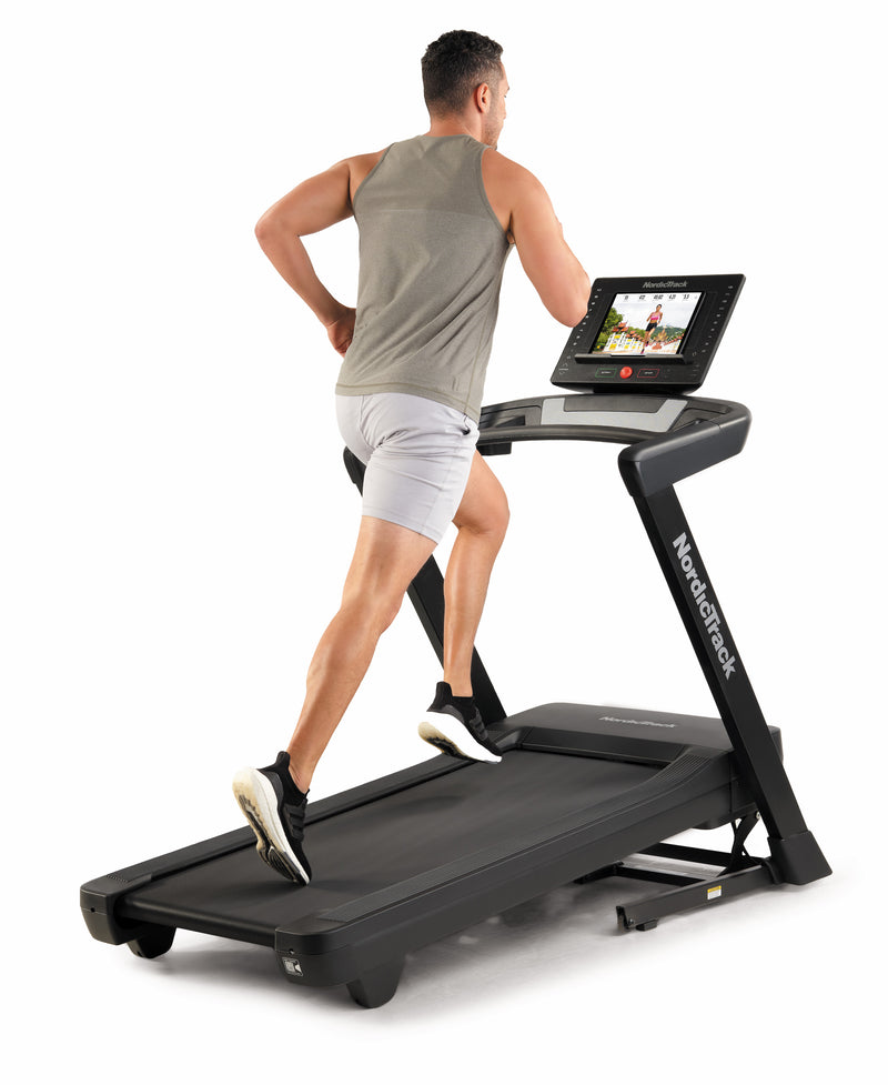 Nordic Track EXP 5i Treadmill with male runner on incline using tablet in studio
