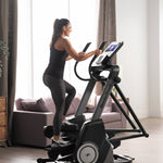 Nordic Track Freestrider Trainer FS10. Side view of a female working out on the Freestrider in a domestic setting.