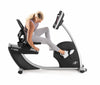 Nordic Track R35 Recumbent Bike. Side view of a female demonstrating how to change the seat position.