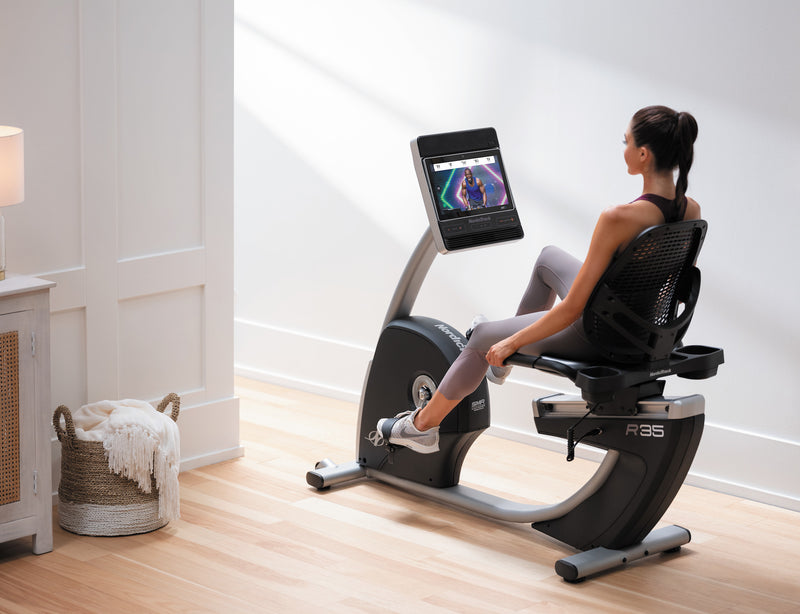 Nordic Track R35 Recumbent Bike. Image of a female working out on the recumbent in a domestic setting.