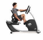 Nordic Track R35 Recumbent Bike. Side view of a male programming the console  whilst working out.