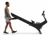 Nordic Track RW700 Rower. Male showing how easy it is to move the rower, lifting it up at the back and pushing it across the floor on its transport wheels.