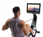 Nordic Track RW900 Rower. Image showing a male looking at the console on the rower whlist in a programme.