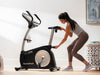 Nordic Track VU29 Upright Bike. A female demonstrating how to alter the seat height.