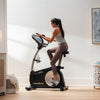 Nordic Track VU29 Upright Bike.  A side view of a female working out on the VU29 upright bike in a domestic setting.