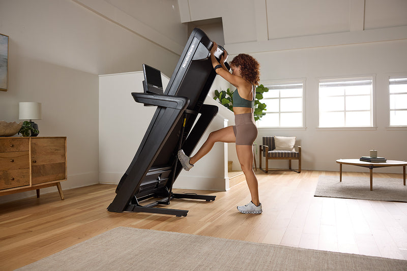 Woman folding NordicTrack Commercial 1750 in room setting