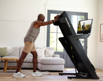 NordicTrack Commercial 2450 Treadmill folded by male in room setting