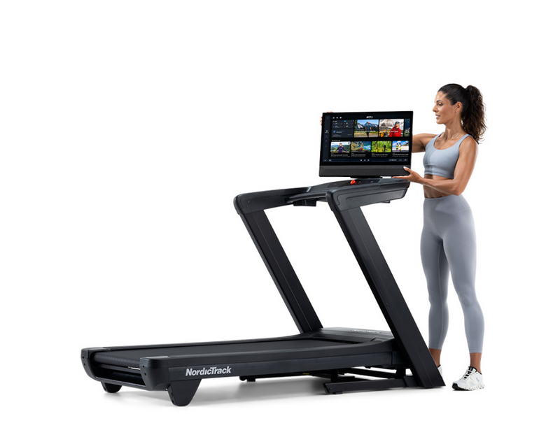 NordicTrack Commercial 2450 Treadmill with woman tilting console against white background