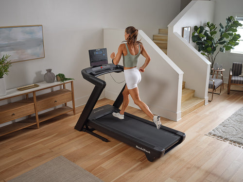 NordicTrack Commercial LE Treadmill with woman running in modern room setting.