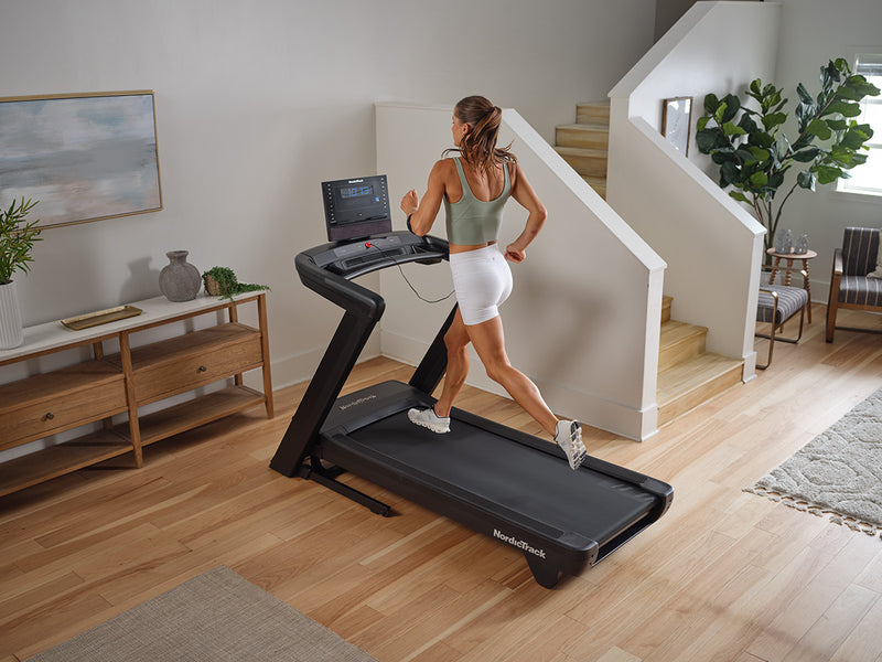 NordicTrack Commercial LE Treadmill with woman running in modern room setting.