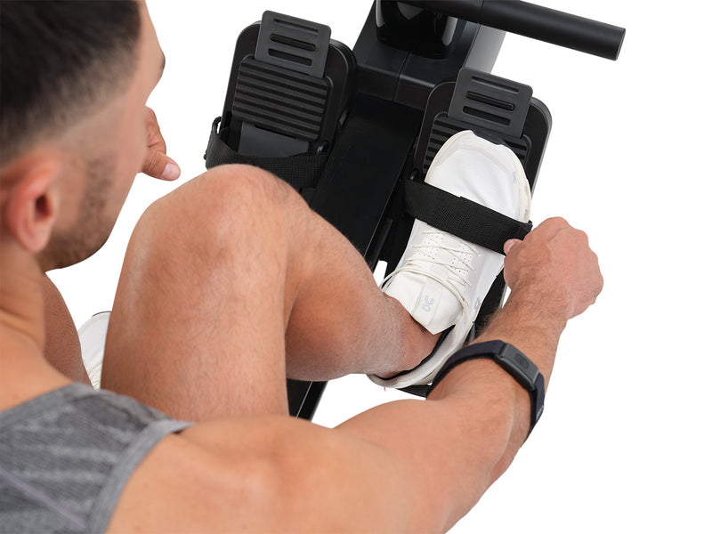 NordicTrack RW300 Rowing machine with man adjusting foot straps