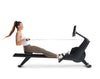 NordicTrack RW300 Rowing machine side view of woman using rower against white background