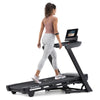 NordicTrack T10 Treadmill slightly elevated with woman walking on it against white background
