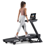 NordicTrack T10 Treadmill slightly elevated with woman walking on it against white background