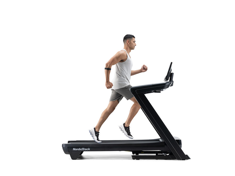 Nordic Track Commercial 1250 Treadmill side view with man running on a flat surface against a white background