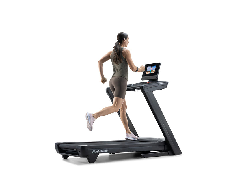 Nordic Track Commercial 1250 Treadmill with woman running on it against a white background.