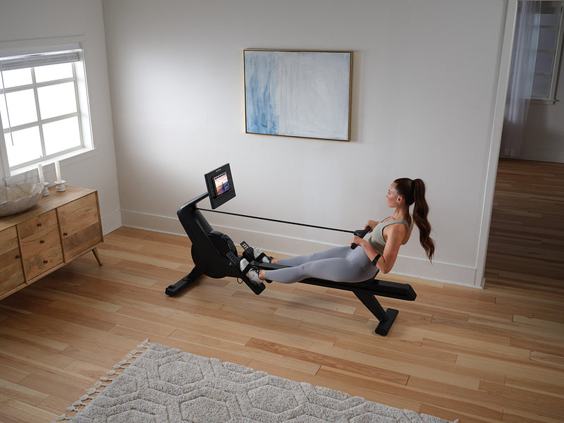 Overhead view of NordicTrack RW300 Rowing machine being used by woman in room setting 
