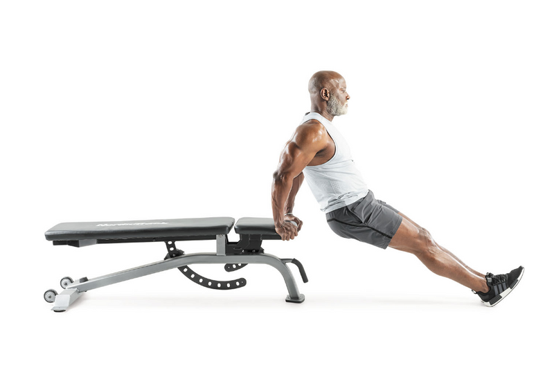 Nordic Track bench with male doing dips on the end of the bench