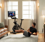 Nordic Track S22i Studio Bike in room with male model exercising on the floor
