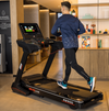 Male model running on the BH  Inertia Smart Focus RS900 Treadmill in a room setting. Available at Fitness Options. www.fitnessoptions.co.uk