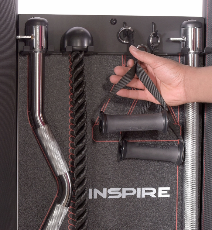 Hand holding accessory stirrup handle attached to the accessory rack at the rear of the machine