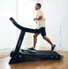 Side view of man running on a Bodytone Active Run 600 Smart treadmill in a home setting