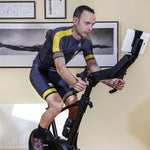 An image of a man cycling on the BH Exercycle Smart Bike looking at his tablet fixed to the front of the bike. Fitness Options, Online Gym Equipment Supplier and Nottinghamshire Showroom
