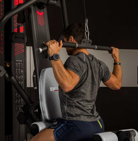 Image of a person using the lat pulldown station on the BH Indar multi station gym.  
