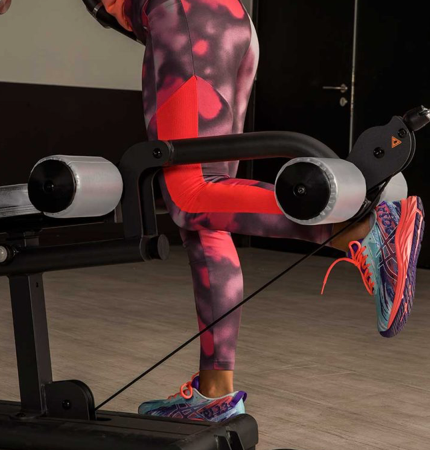 Image of a person performing a hamstring curl  using the leg unit on the BH Indar multi station gym.   