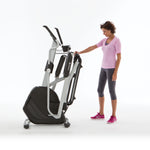 Side view of a female standing next to a fully folded Horizon Andes 7i Cross Trainer.  Fitness Options, Online Gym Equipment Supplier and Nottinghamshire Showroom