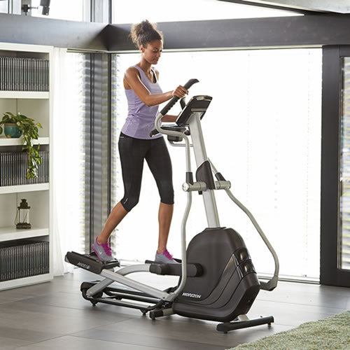 Side view of a female working upper and lower body on the Horizon Andes 7i folding cross trainer. Fitness Options, Online Gym Equipment Supplier and Nottinghamshire Showroom